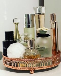Bandeja decorativa rose gold com perfumes de vários tamanhos