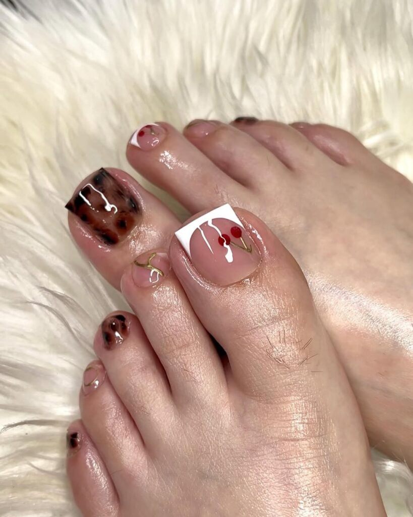 Pés de pele clara, com pedicure decorada com francesinha, cerejas e estampa de tartaruga