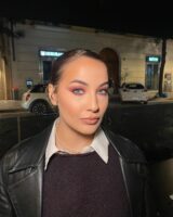 Mulher de pele clara, com maquiagem em tons de vermelho-cereja