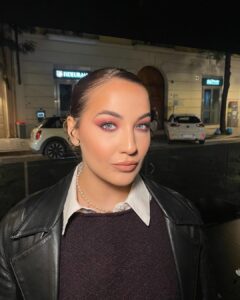 Mulher de pele clara, com maquiagem em tons de vermelho-cereja