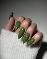 Mão de pele clara, com unha amendoada verde-oliva