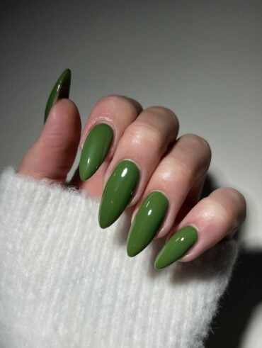 Mão de pele clara, com unha amendoada verde-oliva