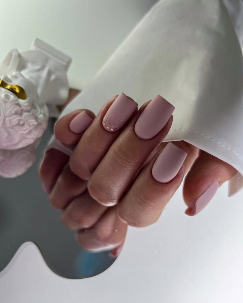 Mão de pele clara, com unha quadrada neutra com acabamento matte