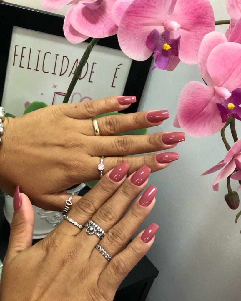 Mãos de pele "média", com anéis em prata e dourado e unha coffin rosa antigo 