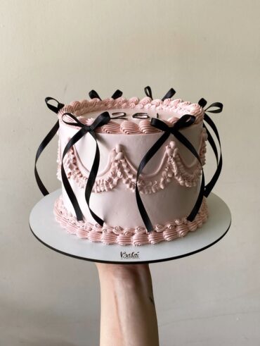 Bolo vintage rosa com laços pretos
