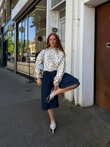 Mulher jovem com look com casaco de poá e bermuda jeans