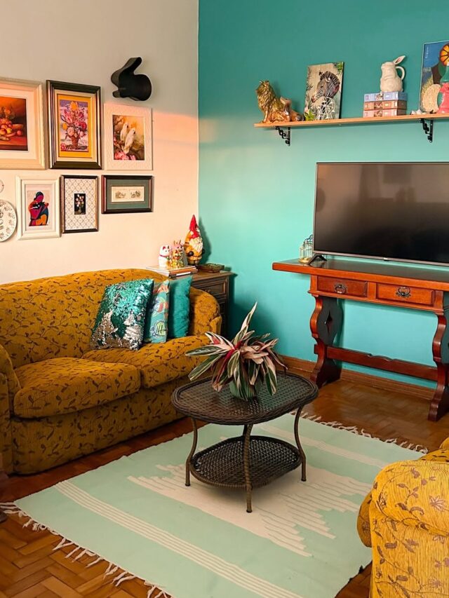 Sala vintage com sofá em tom de mostarda, aparador de madeira com tv e pratos na parede