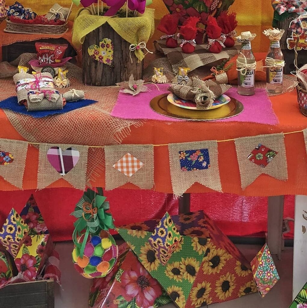 Mesa decorada com bandeirinhas de juta e retalhos coloridos