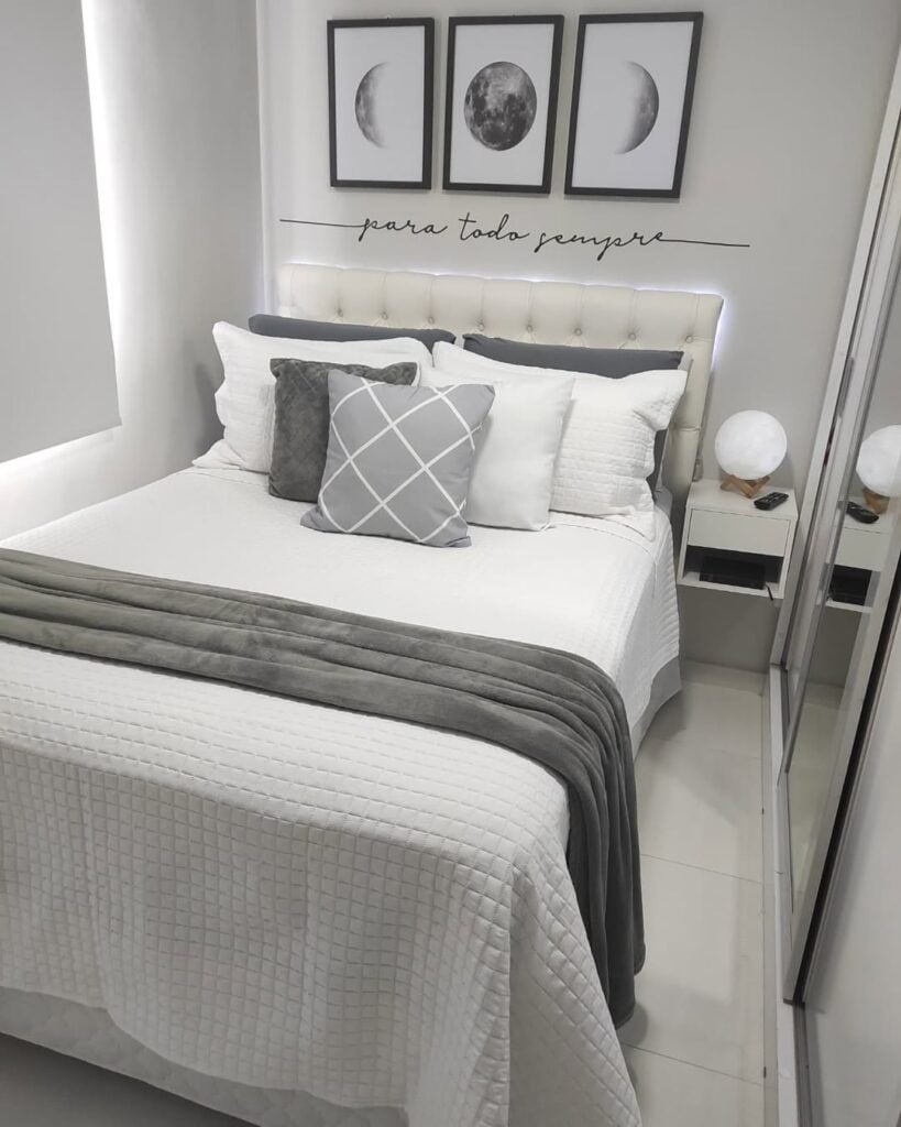 Quarto em tons de branco e cinza com cama posta branca e manta cinza aveludada