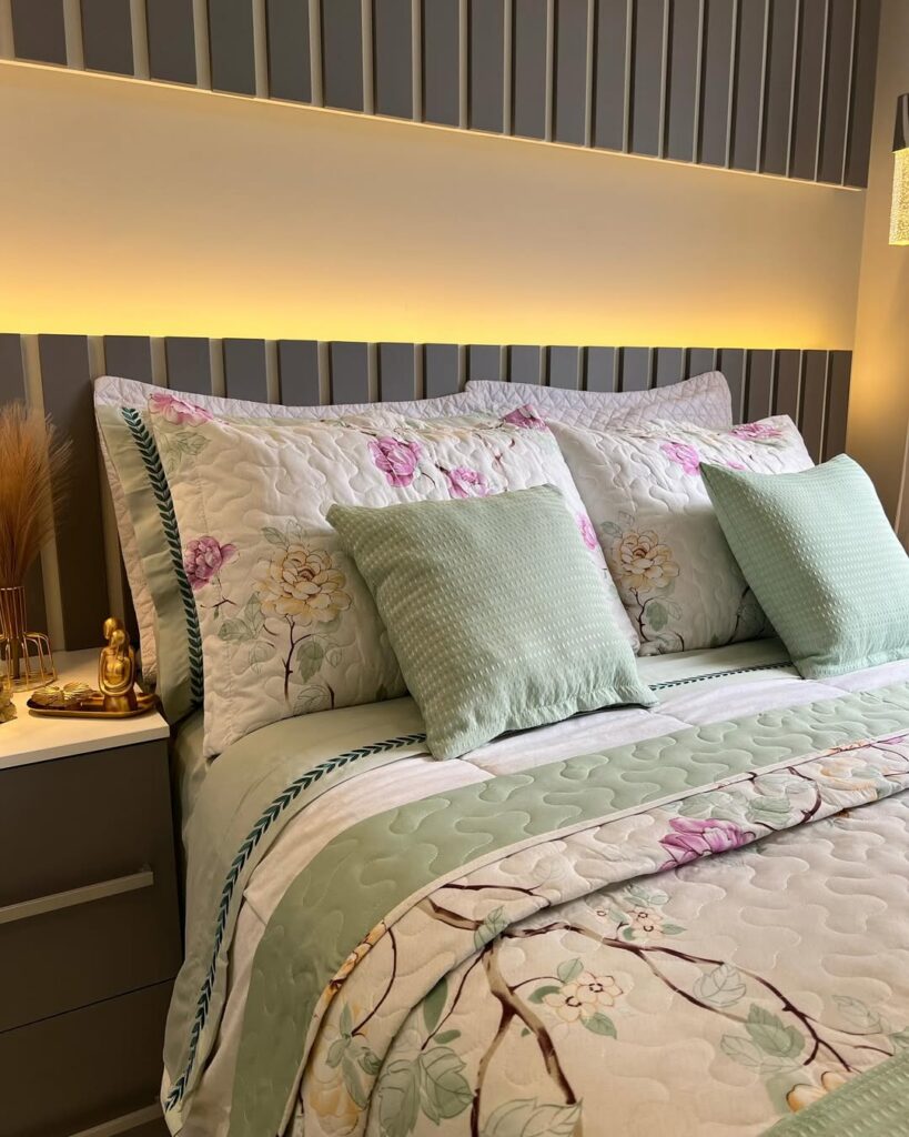 Quarto de casal com cabeceira ripada, colcha branca com flores e almofadas verde