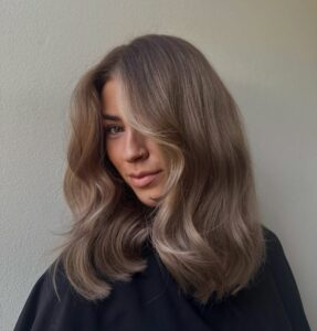 Mulher de pele clara, com blusa preta e cabelo castanho