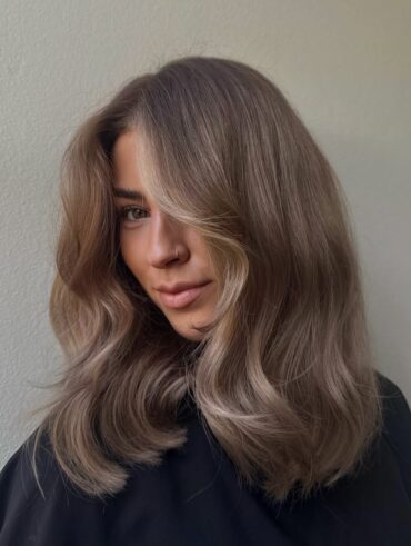 Mulher de pele clara, com blusa preta e cabelo castanho