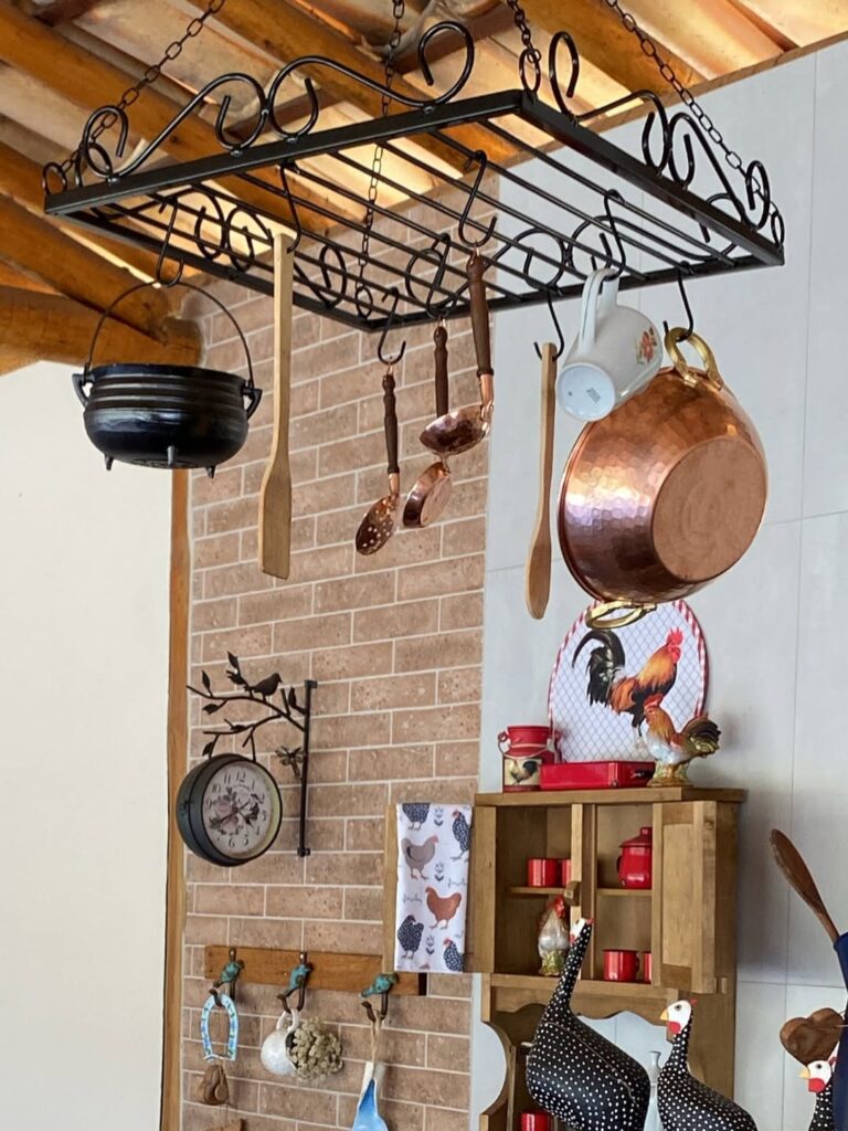 Suporte de ferro pendurado com panelas e utensílios de cozinha