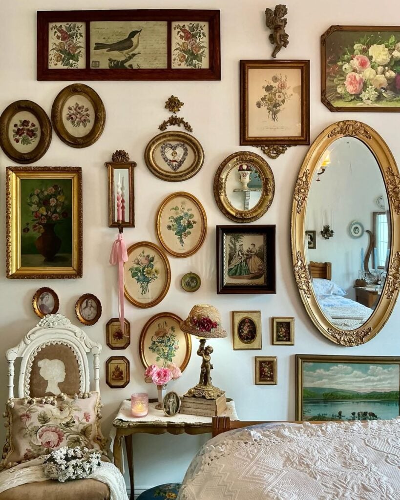 Parede com quadros de molduras dourada com flores e espelho oval
