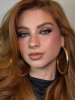 Mulher de pele clara, com cabelo ruivo e maquiagem clean