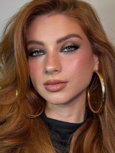 Mulher de pele clara, com cabelo ruivo e maquiagem clean