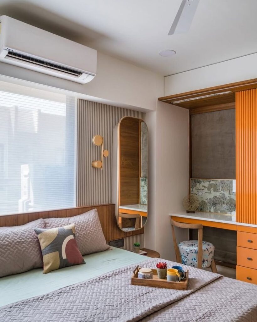 Quarto de casal com espelho oval e escivaninha com gavetas laranja