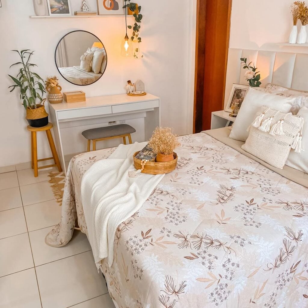Quarto de casal em tons claros e itens amadeirados, penteadeira branca com banqueta e espelho redondo