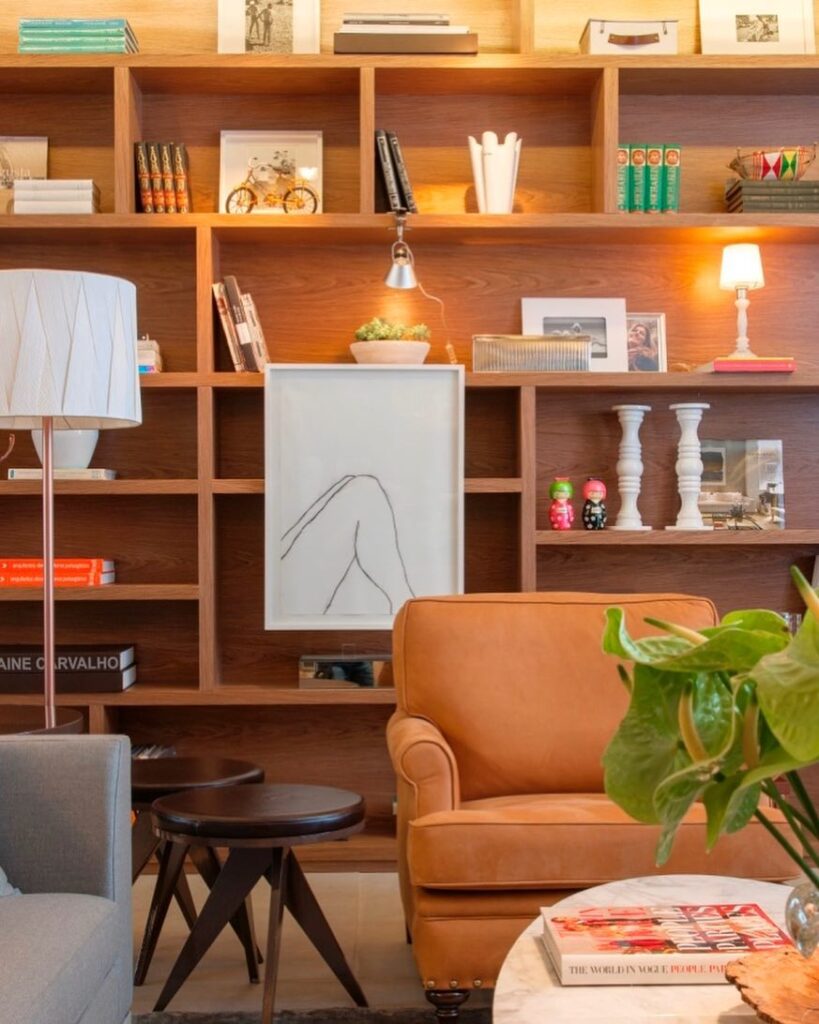 Sala de estar com estante de madeira, livros e objetos decorativos