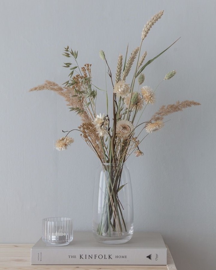 Vaso transparente com flores e galhos secos