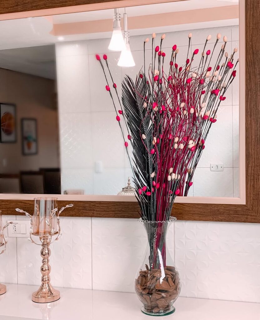 Vaso transparente de vidro com galhos secos marrom e rosa