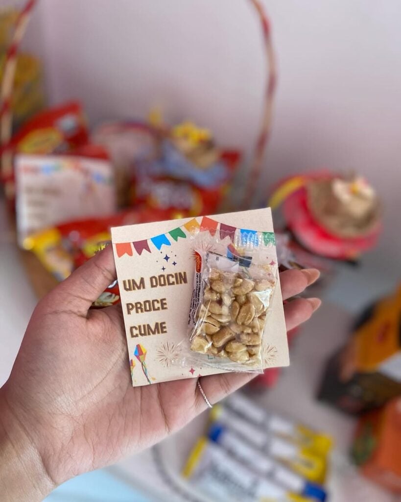 Cartãozinho decorado com bandeirinhas e uma embalagem de pé de moleque