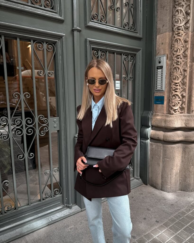 Mulher jovem com blazer marrom, camisa e calça jeans