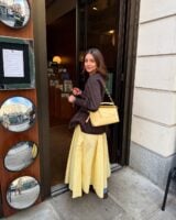 Mulher jovem com look marrom e amarelo