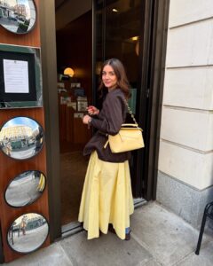 Mulher jovem com look marrom e amarelo