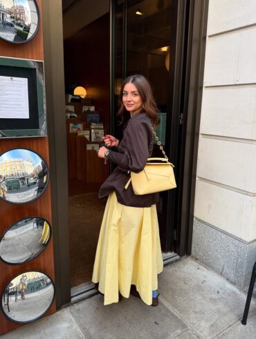 Mulher jovem com look marrom e amarelo