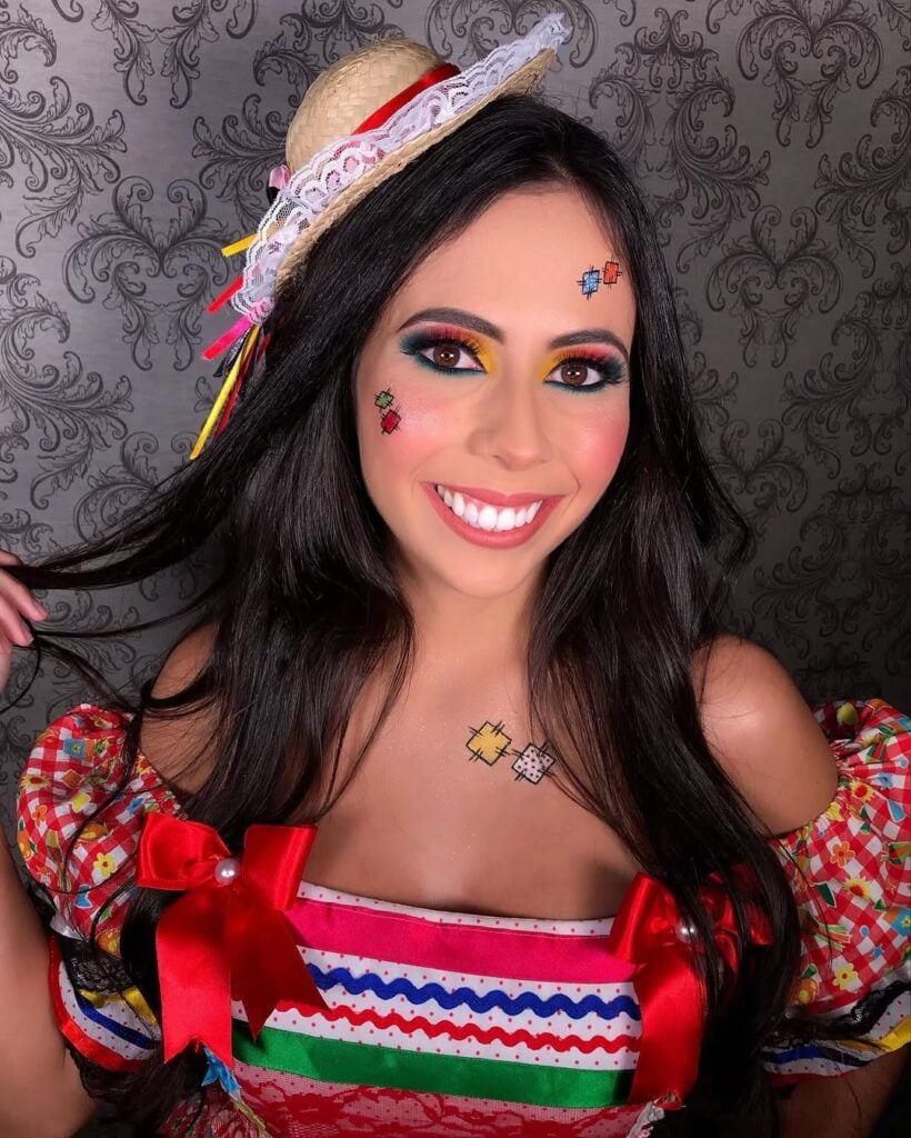 Mulher de pele clara, com cabelo escuro e look, penteado e maquiagem de São João