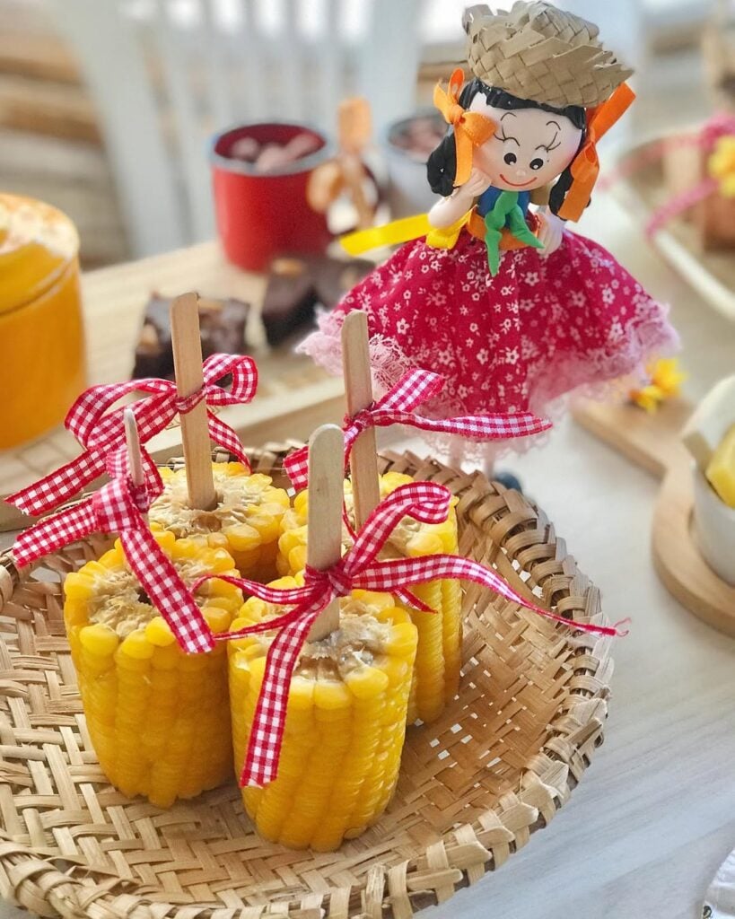 Espigas de milho com palito e laço xadrez e bonequinha de pano