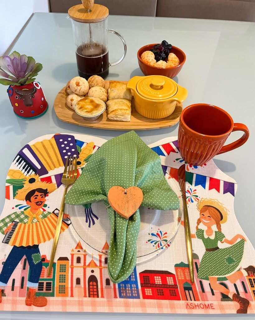 Mesa posta com jogo americano junino, guardanapo verde com bolinhas brancas e anel em formato de coração