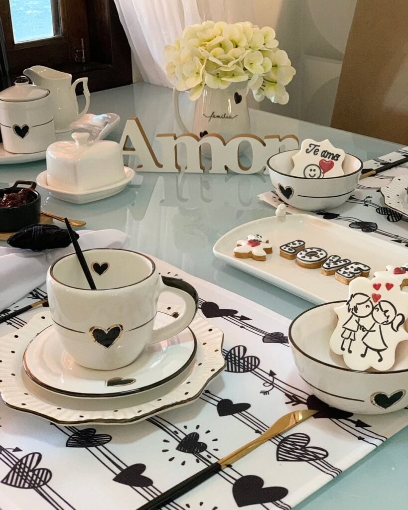 Mesa posta romântica em branco e preto com vaso de flores, louças brancas com corações pretos