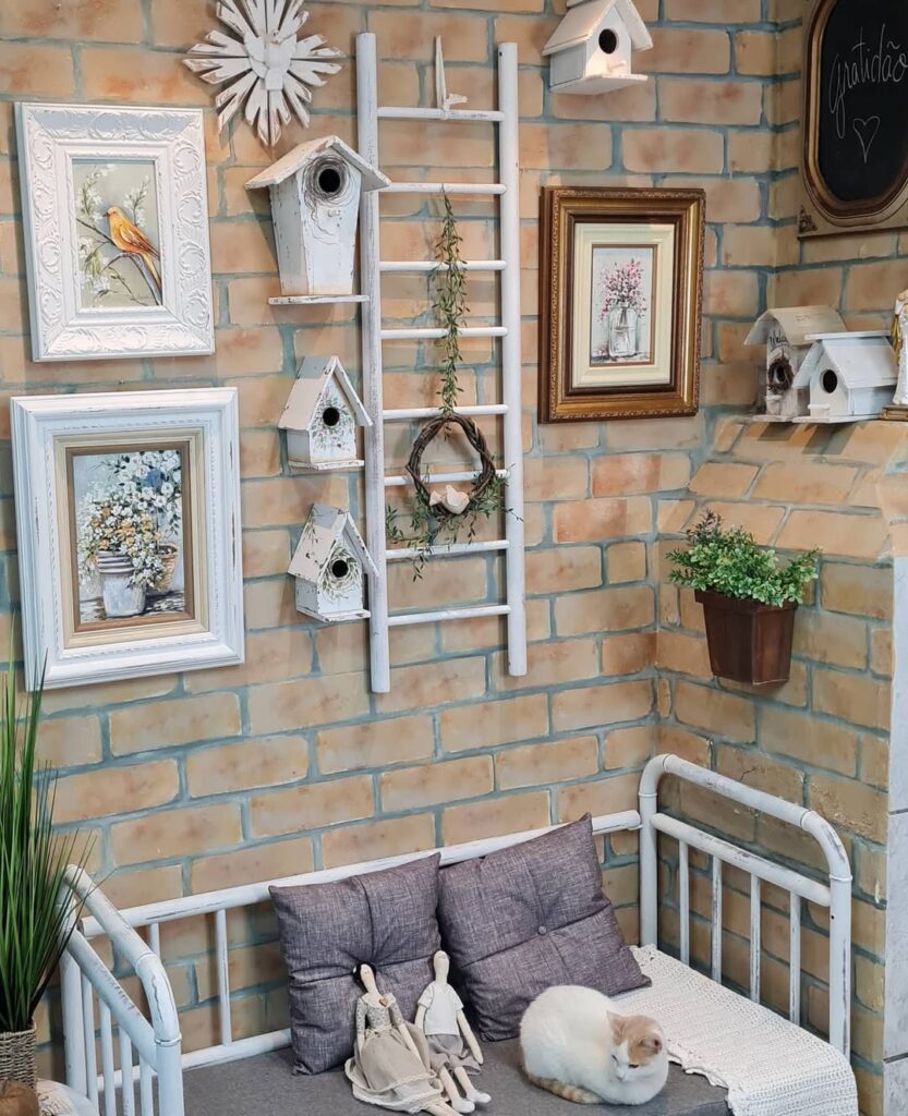 Parede de tijolinhos com quadros e enfeites e berço transformado em sofá