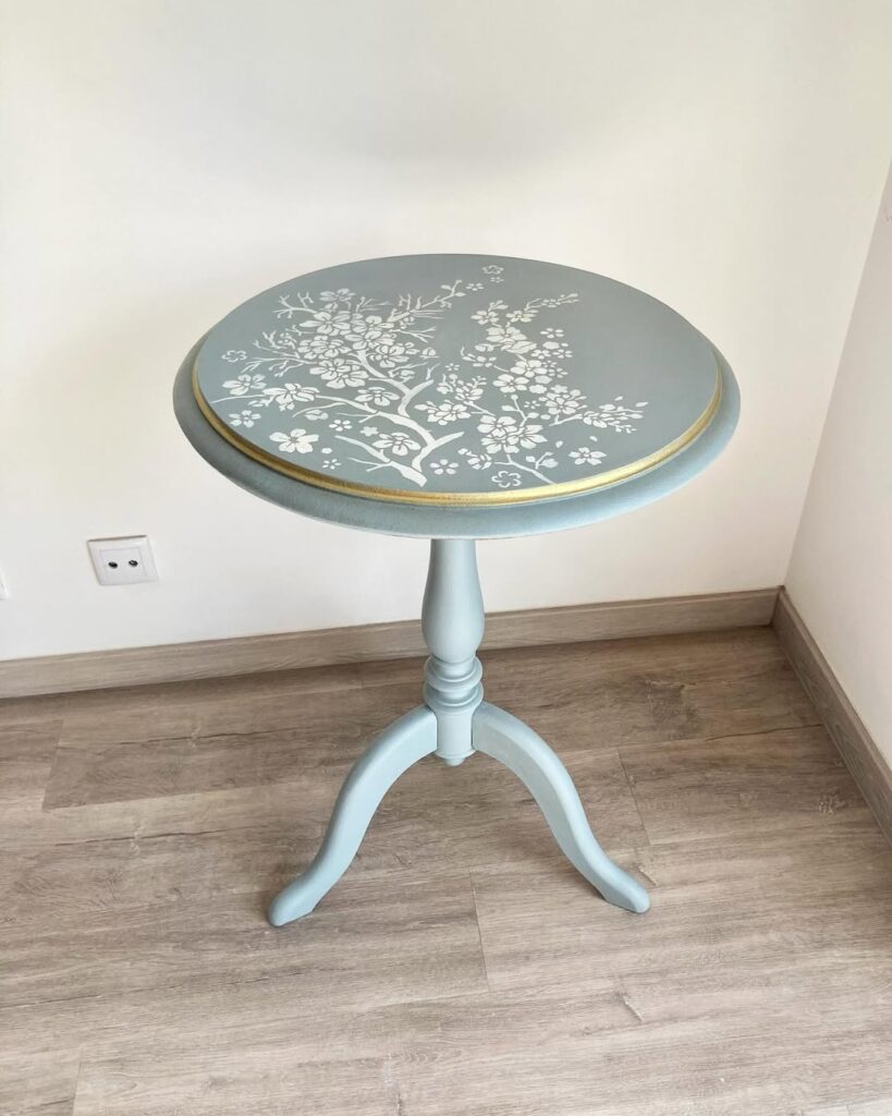 Mesinha azul-claro com decoração com flores brancas e borda dourada
