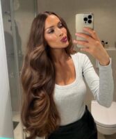 Mulher de pele clara, com blusa cinza e cabelo com ondas