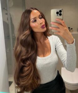 Mulher de pele clara, com blusa cinza e cabelo com ondas