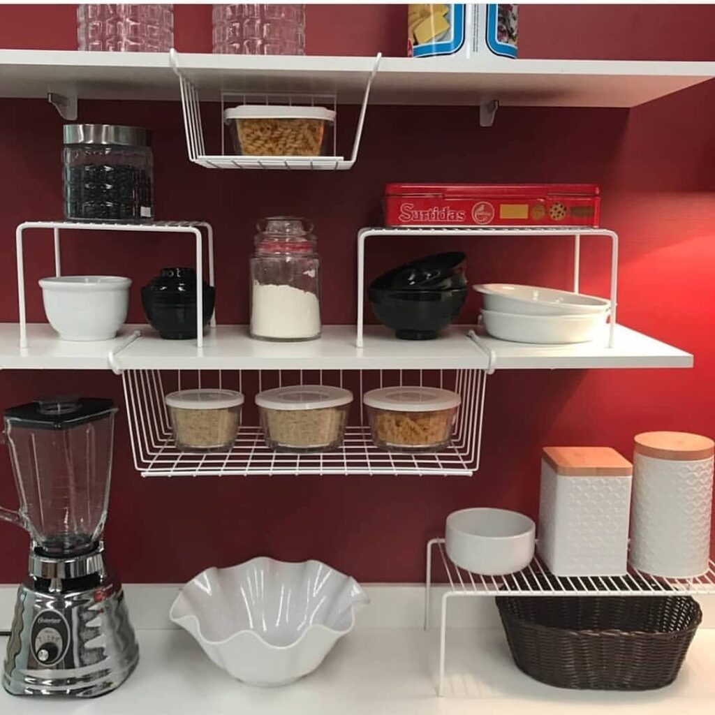 Cozinha com parede vermelha, prateleiras em mdf e aramadas