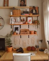 Bancada de trabalho com prateleiras de madeira, livros e itens decorativos