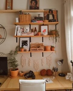 Bancada de trabalho com prateleiras de madeira, livros e itens decorativos