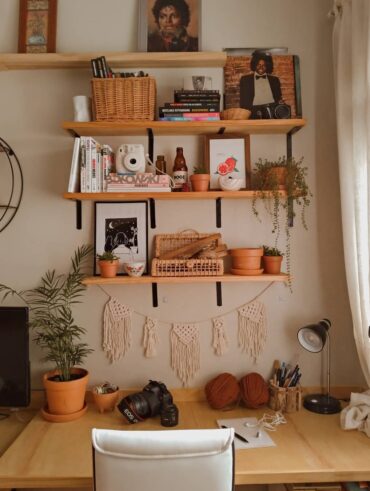 Bancada de trabalho com prateleiras de madeira, livros e itens decorativos