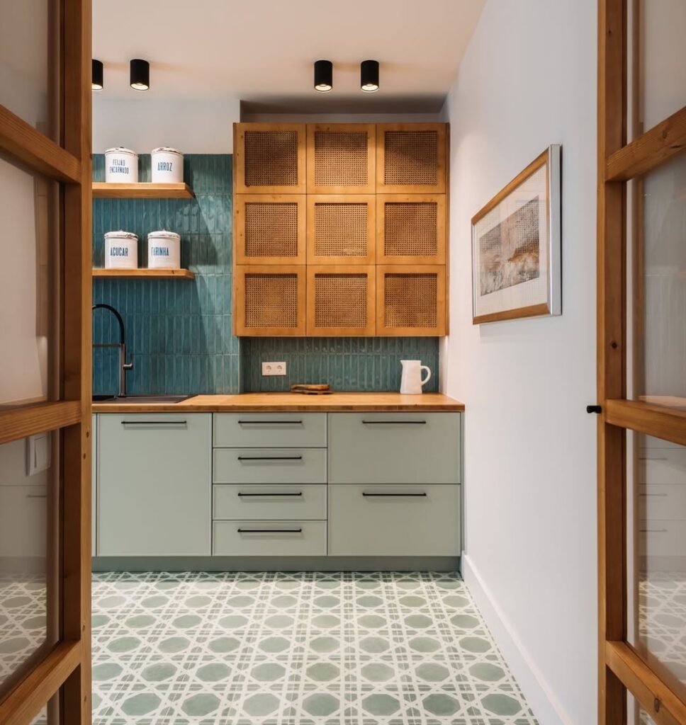 Cozinha com armário cinza e puxadores pretos, armário de madeira, azulejo azul na parte da pia e piso com outro padrão
