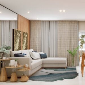 Sala de estar com sofá de linhas retas clato, almofadas brancas e azuis, e três mesas laterais de tamanhos diferentes