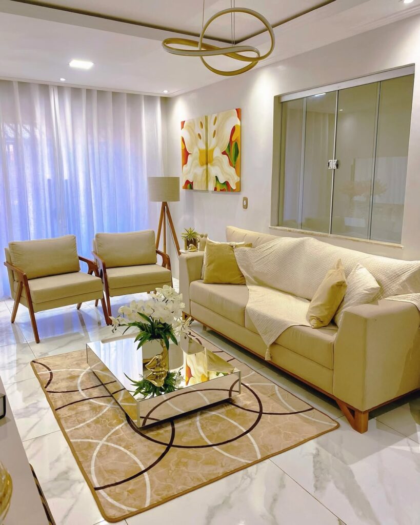 Sala em tons de branco e amarelo, tapete com círculos e mesa de centro espelhada