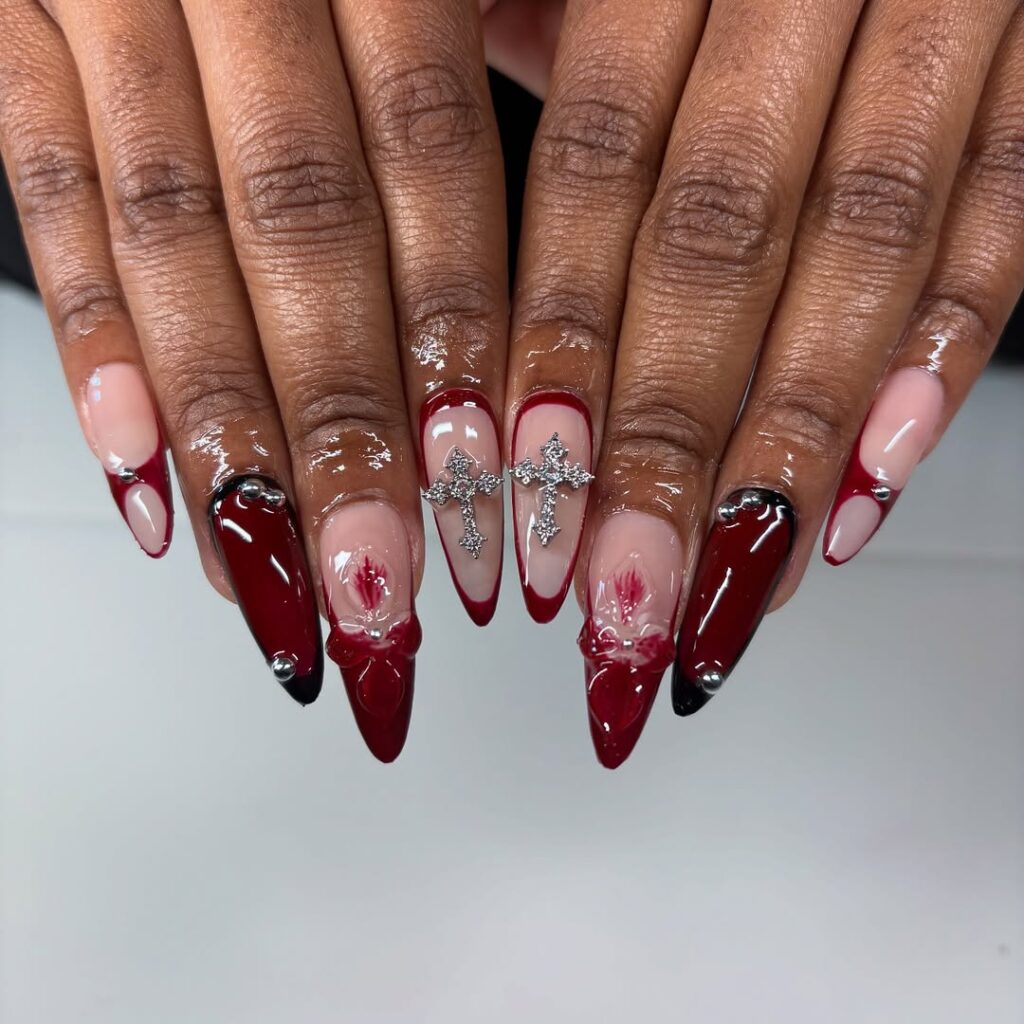 Mãos de pele preta, com unha amendoada com decorações em vermelho
