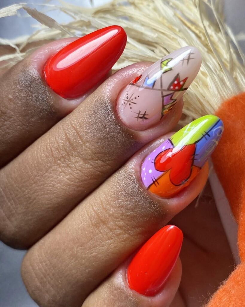 Mão de pele prta, com unha amendoada vermelha com decoração de bandeirinha