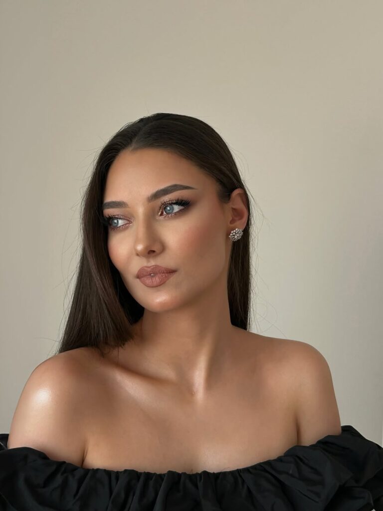 Mulher de pele clara, com cabelo castanho e maquiagem elegante