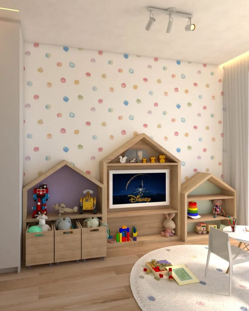 Brinquedoteca com papel de parede branco e bolinhas coloridas, móveis de madeira e caixas com brinquedos