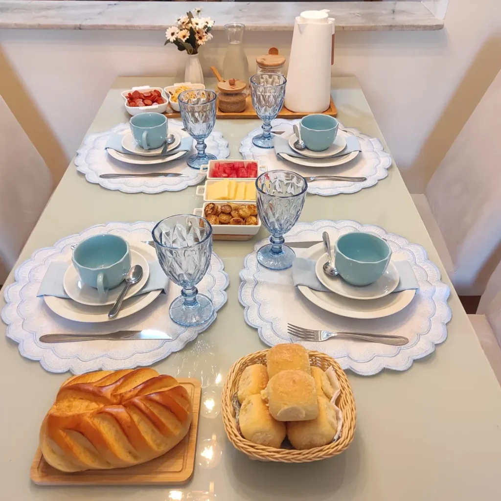 Mesa posta de dia dos pais com pães, frios e decoração em azul e branco
